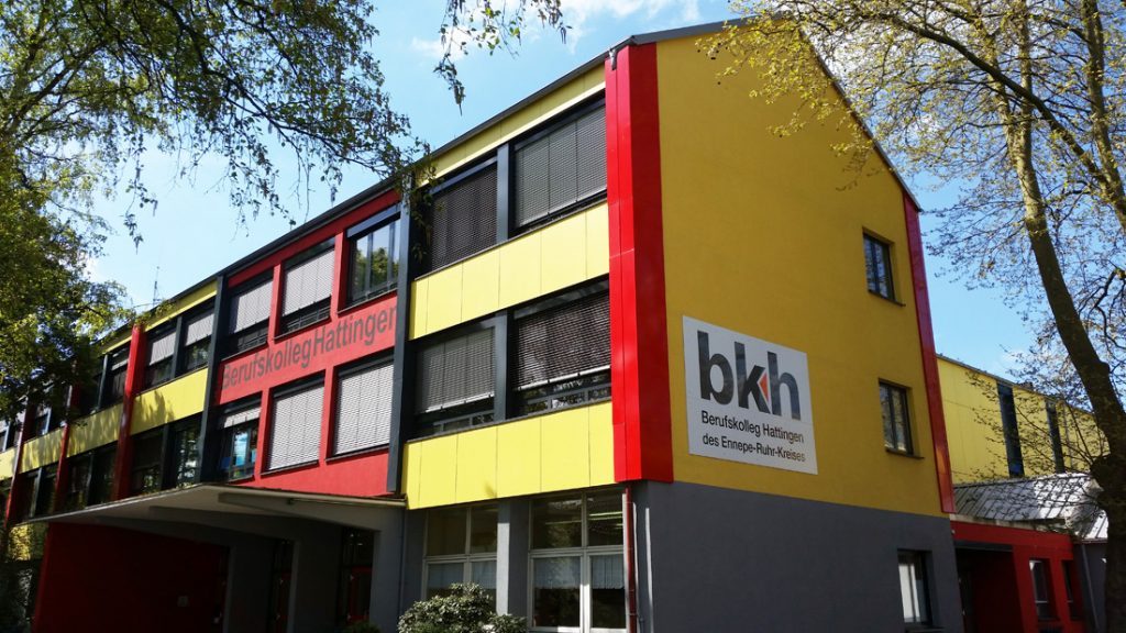 Das Berufskolleg Hattingen von außen, ein Gebäude mit roter, gelber und grauer Fassade